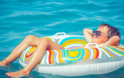 a woman lying on a floaty in a pool