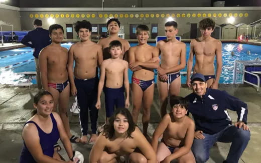 a group of people posing for a photo in front of a pool