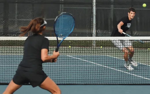 a woman hitting a ball with a tennis racket