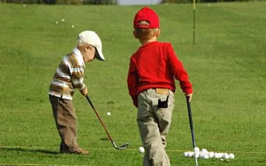 a couple of boys playing golf