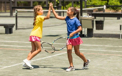 girls playing tennis on court