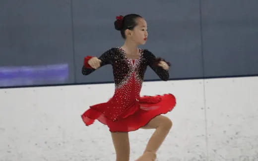 a person wearing a red dress and ice skating