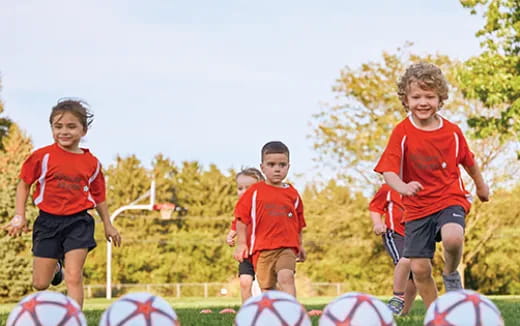 a group of kids running on a field