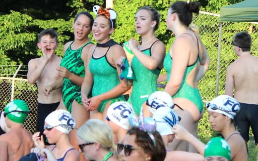 a group of people in green swimsuits