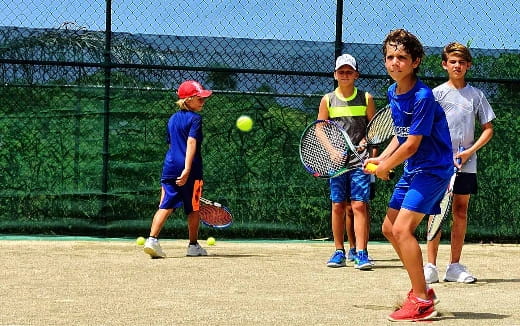 kids playing tennis on court