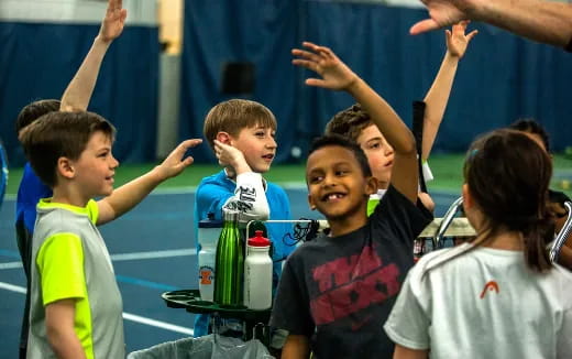 a group of children raising their hands