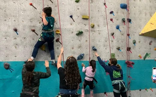 a group of people climbing a rock wall