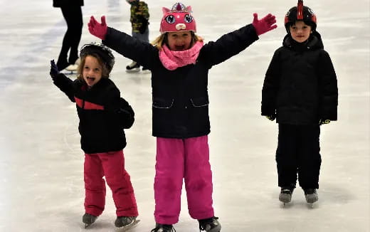 a group of children wearing ice skates and helmets