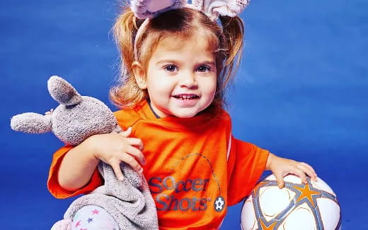 a little girl holding a stuffed animal