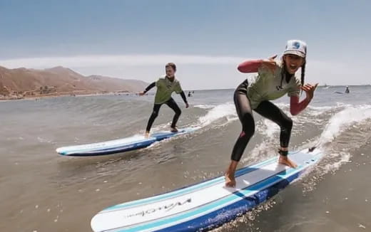 a couple of people surfing on the sea