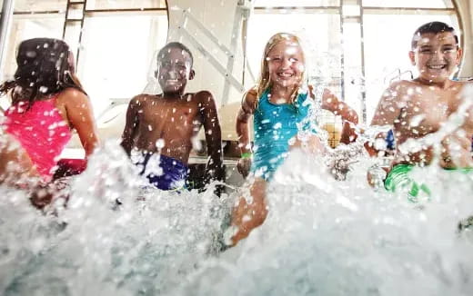 a group of kids playing in a pool