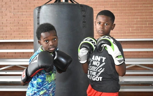 a couple of boys wearing boxing gloves