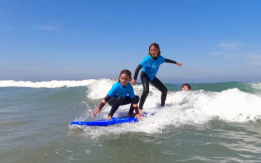 a man and a couple kids riding a surfboard