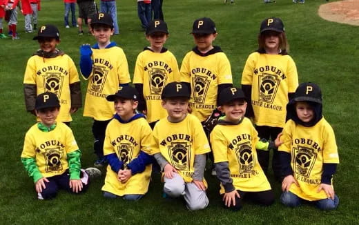 a group of kids wearing matching yellow shirts and hats