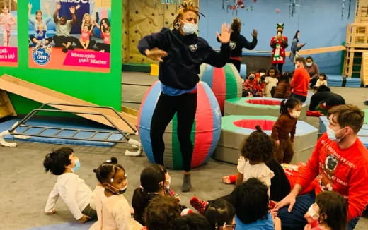 a person standing on a stage surrounded by children