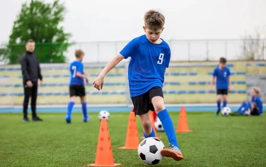 a boy kicking a football ball
