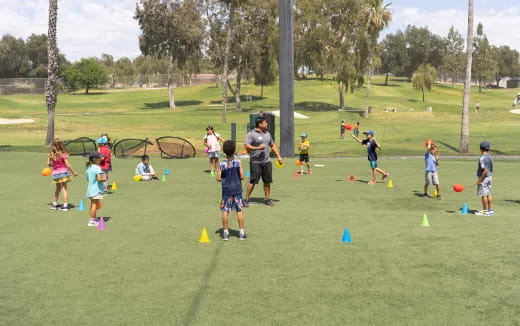 a group of kids playing with a ball in a park