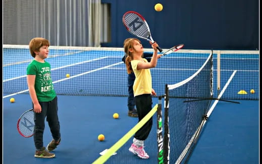 kids playing tennis on a court