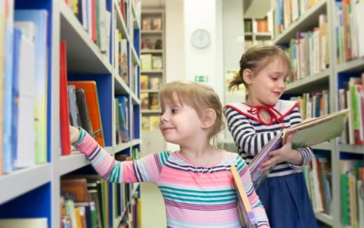 a couple of young girls in a library