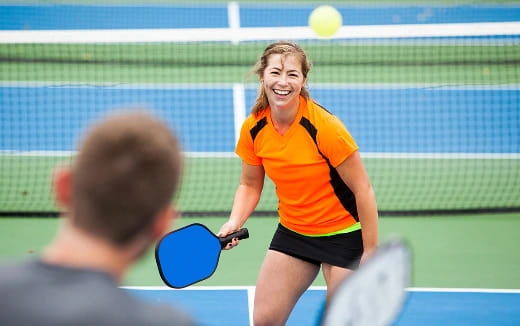 a woman hitting a ball with a tennis racket