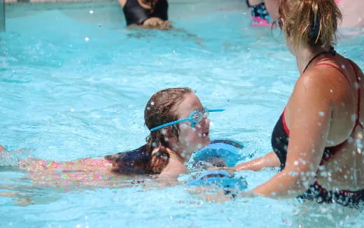 a woman in a pool with a man in the water