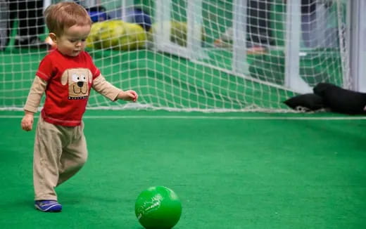 a boy playing with a ball