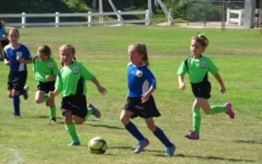 a group of girls compete over a football ball