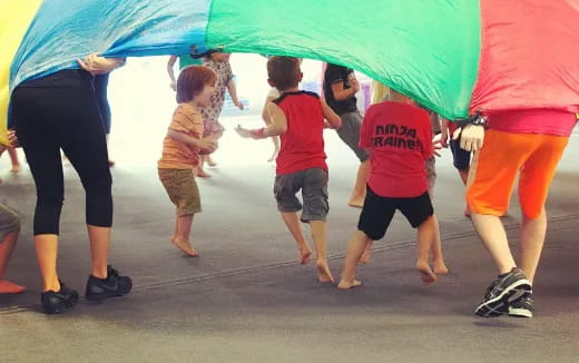a group of children playing with an umbrella