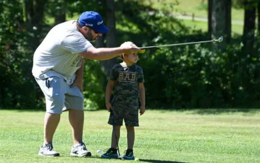 a person and a boy playing golf