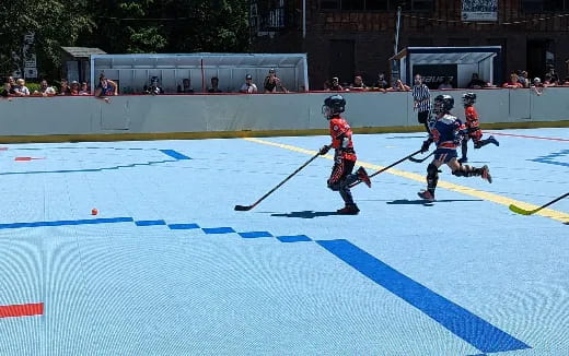 kids playing hockey on a court