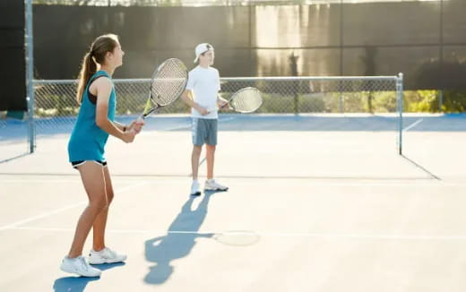 a couple of people play tennis