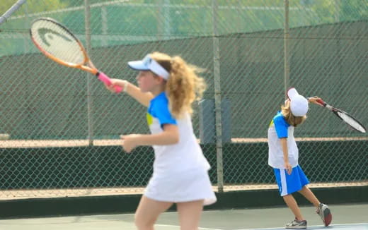 a woman and a kid playing tennis