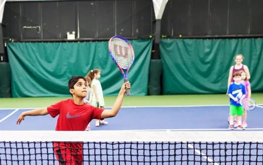 a kid playing tennis