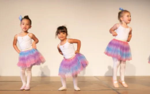 a group of girls wearing dresses and dancing