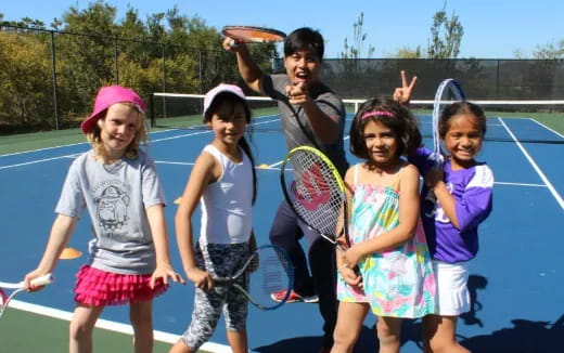 a group of kids holding tennis rackets