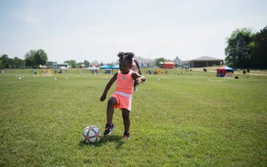 a girl kicking a football ball