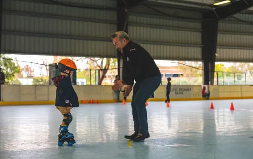 a man and a boy on an ice rink