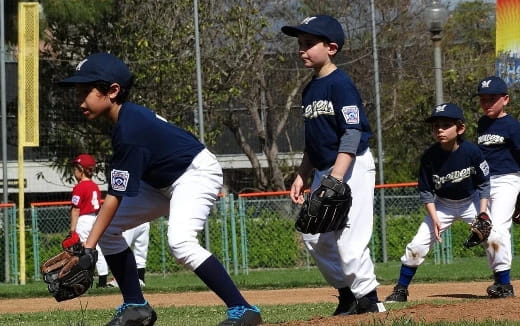 a kid in a baseball uniform prepares to throw a baseball