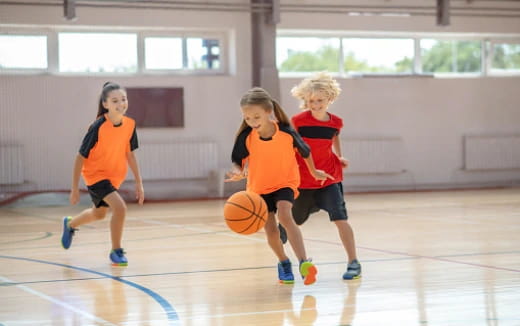 a group of kids playing basketball