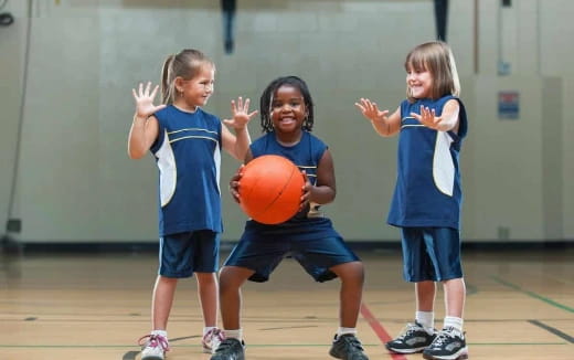 a group of kids playing basketball