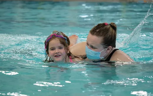 a person and a girl swimming in water