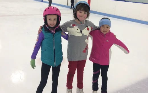 a group of children wearing helmets and ice skates