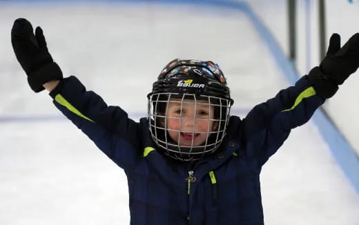 a person wearing a helmet and goggles with their arms up