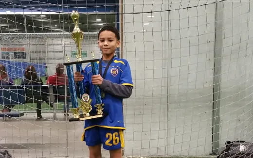 a boy holding trophies