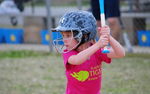 a little girl playing baseball