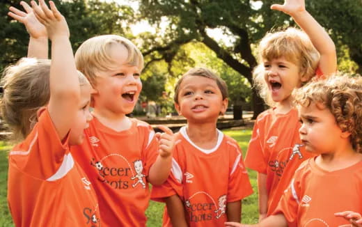 a group of kids in orange shirts