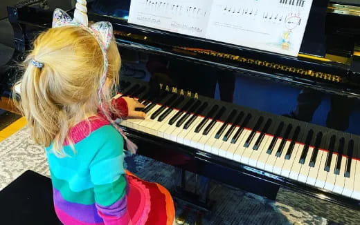 a little girl playing a piano