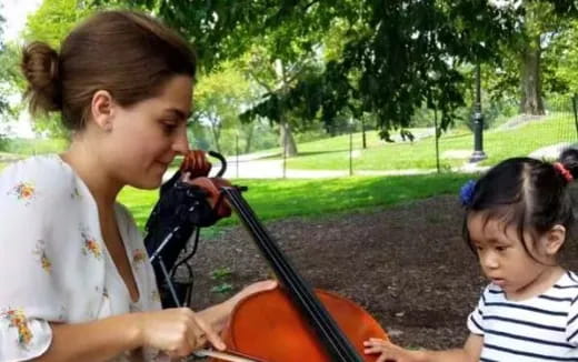 a person playing a violin next to a young girl