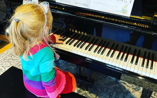 a little girl playing a piano