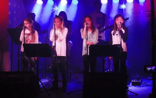 a group of women singing on a stage